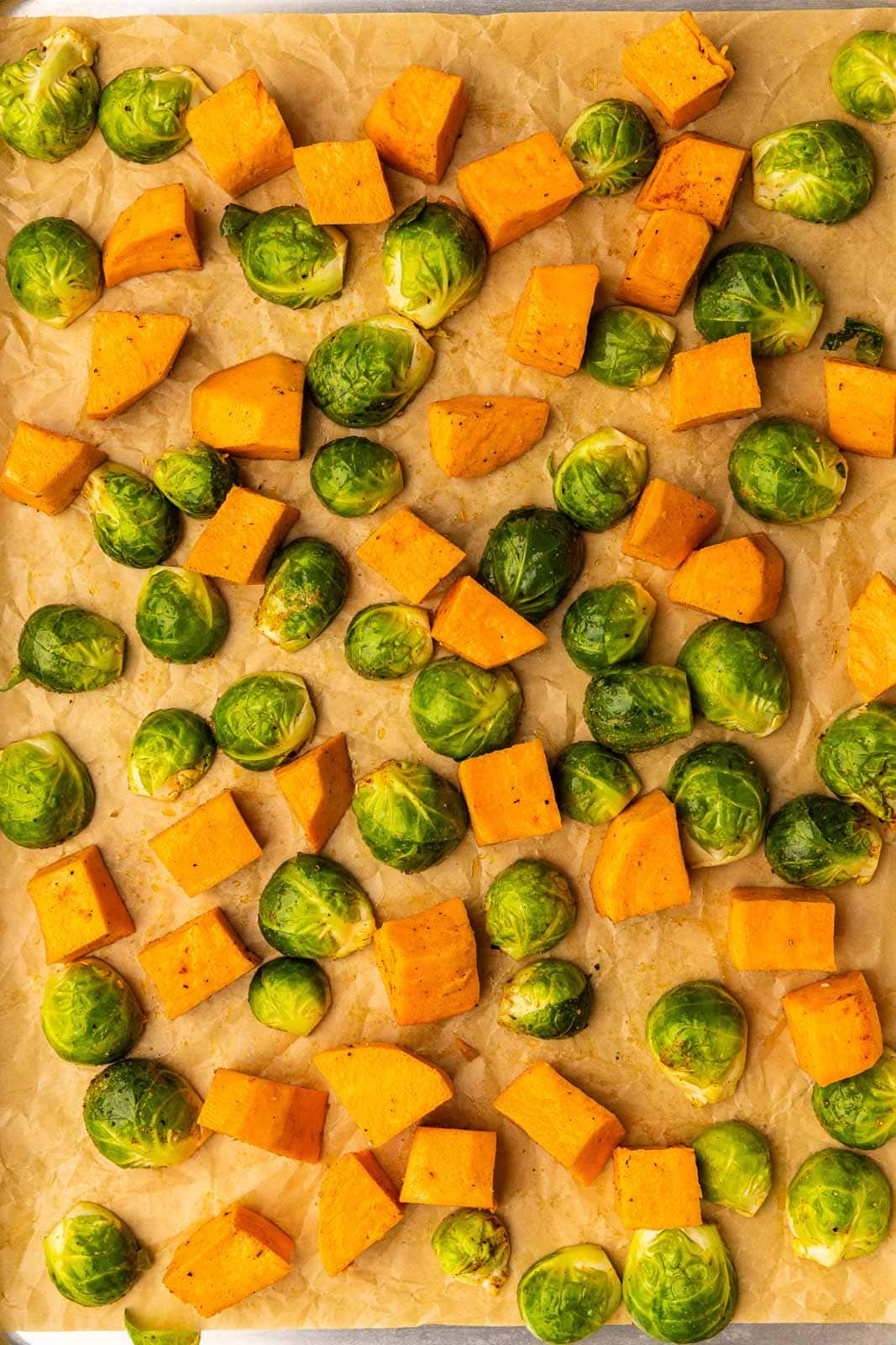 parchment paper with Brussels sprouts and sweet potatoes