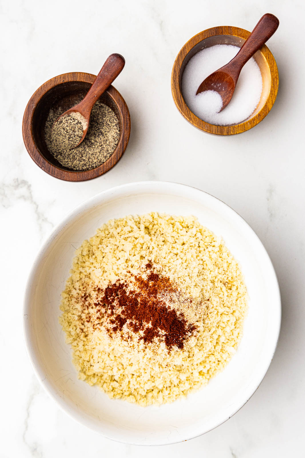 large bowl of breadcrumbs with seasoning, with bowls of salt and pepper on side