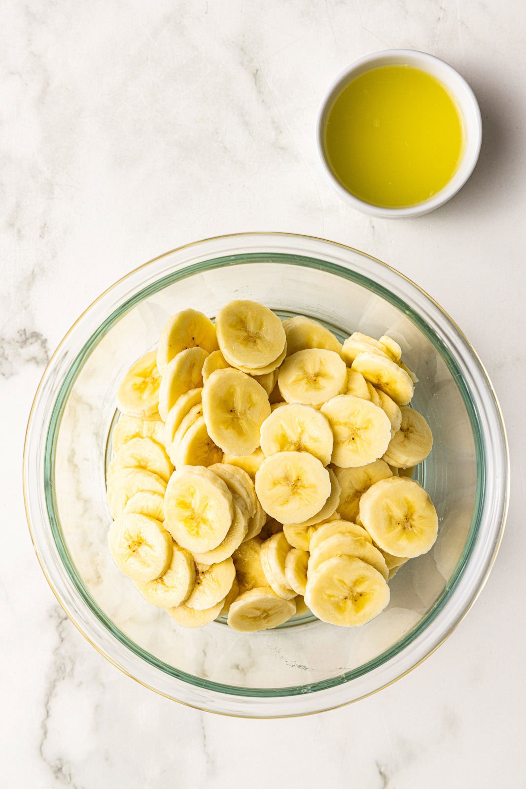 bowl of sliced bananas with bowl of lemon juice on side