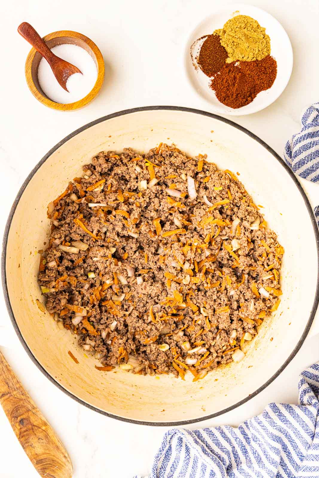 overhead view of ground mixture with containers of salt and mixed seasonings on side