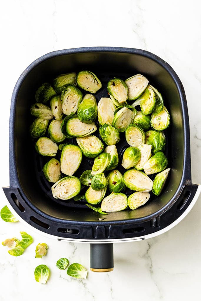 overhead view of air fryer with prepped Brussels sprouts