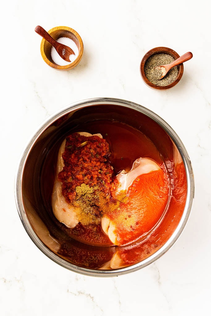 instant pot with chicken breasts with all ingredients, with salt and pepper on side